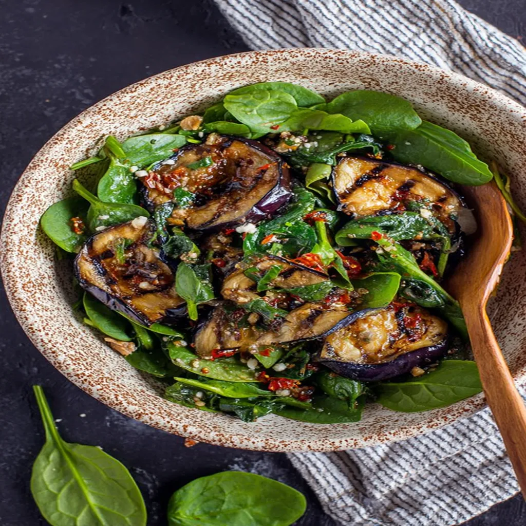 Grilled eggplant, spinach salad, flavorful, fresh, vibrant colors